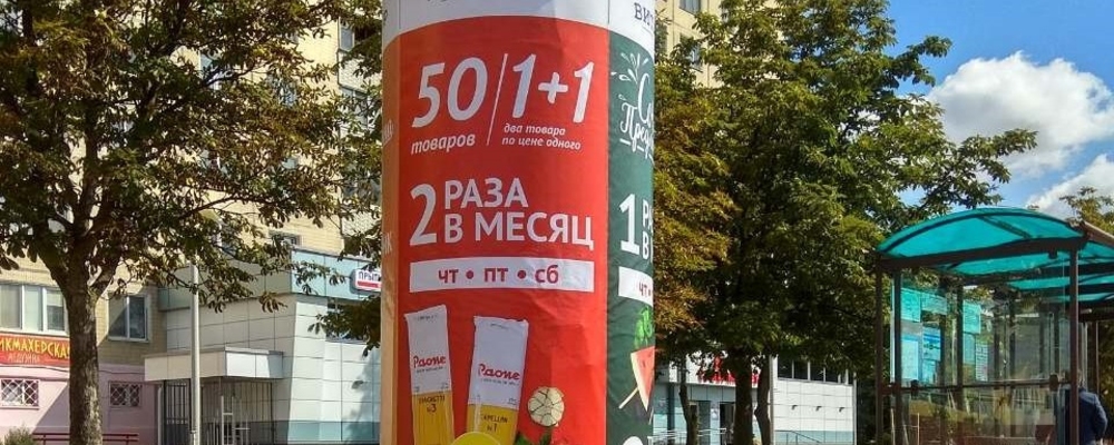 Уличная рекламная тумба с афишей кинофильма возле торгового центра