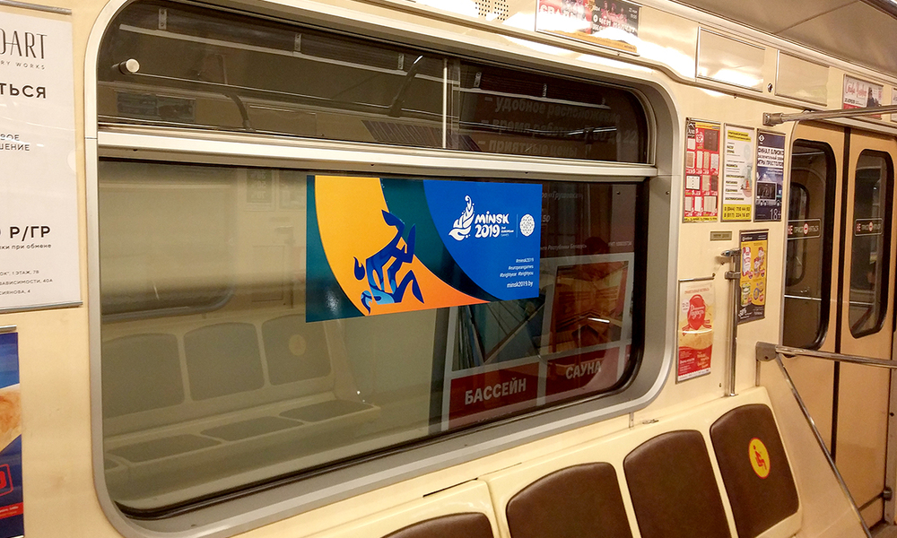 Вид через стекло метро с размещённым рекламным стикером, оформление интерьера транспорта